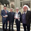 Quatre personnes, dont la ministre de la Réconciliation avec les peuples autochtones et des Relations avec le Nord, Eileen Clarke, posent à l'intérieur du Palais législatif du Manitoba, le 7 février 2023. 