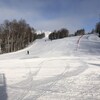 Des skieurs au loin descente la pente de ski du Mont Kanasuta.