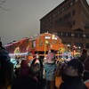 Des gens devant un train illuminé.