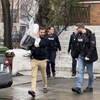 Un enquêteur transporte un ordinateur à la sortie d'une résidence.