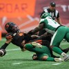 L'ailier défensif Pete Robertson met à terre Vernon Adams Jr. lors d'un match contre les Lions de la Colombie-Britannique le 22 juillet 2023.