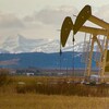 Deux chevalets de pompage devant les Rocheuses albertaines.