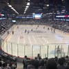 Des joueurs de hockey avec des centaines de personnes qui les regardent jouer.