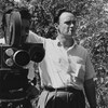 Pierre Gauvreau, cigarette à la bouche, lors d'un tournage extérieur à l'Île
Perrot. Il se tient aux côté d'un caméraman. 