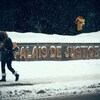 Une femme passe devant l'enseigne du palais de justice de Montréal, sous une fine neige. Un homme s'allume une cigarette à l'entrée de l'édifice.