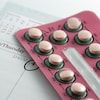 Des pilules contraceptives dans leur emballage déposé sur un agenda.