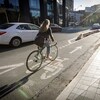 Une cycliste roule sur une piste cyclable au centre-ville de Toronto.