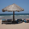 Un homme se fait bronzer sur la plage. 