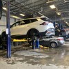 Des voitures surmontées sur des monte-charges pour le changement de pneus dans un garage commercial.