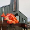 Un poisson rouge géant sur une devanture de commerce.