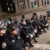 Des agents de la police de New York en tenue anti-émeute entrent dans le campus de l'université de Columbia.