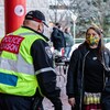 Trois policiers portant le masque discutent avec une femme portant aussi un masque.