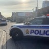 Une voiture de police d'Ottawa est stationnée perpendiculairement à la rue Clarence. Trois policiers debout au centre de la rue parlent à une personne.