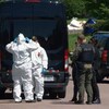 Des policiers en tenue sur une scène d'enquête.