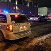 Des véhicules du Service de police de la Ville de Montréal stationnés dans une rue en hiver la nuit.