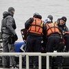 Une équipe de secouristes s'affaire sur un bateau.
