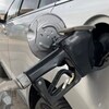 Un pistolet à essence dans la bouche du réservoir d'une automobile.
