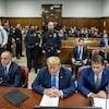Donald Trump, les yeux fermés, assis dans la salle d'audience, entouré de ses avocats.