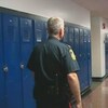 Un policier marche dans le couloir d'une école. 