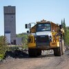 Un camion conduit près d'un chevalement minier.