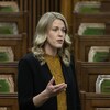 Une femme blonde est debout dans la Chambre des communes.
