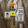 Différentes pancartes de circulation indiquent la vitesse maximale permise dans la zone scolaire ainsi que la présence prochaine de radars photo dans le secteur.