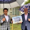 Le promoteur immobilier Rahul Kumar et l'ancien conseiller municipal de Winnipeg Russ Wyatt posent devant la maison qui devait être convertie en habitation qui comporterait six unités.