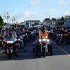Les motocyclistes de La Randonnée du Réfléchi au centre d'une route, prêts à partir.