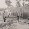Des jeunes construisent une maison, photo en noir et blanc. 
