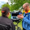 Un homme explique à deux personnes comment les recherches par radar près d'un ancien pensionnat pour Autochtones en Saskatchewan. 