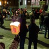 Des personnes qui portent des lampions sont debout devant la galerie les bureaux du Comité de solidarité Trois-Rivières.