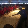 Un homme étend du fromage sur une poutine géante