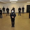 Onze policiers se tenant debout dans une salle.