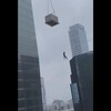 Un homme suspendu dans les airs près de gratte-ciel.