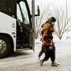 Une femme et son enfant viennent de descendre d'un autocar à Edmonton.