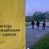 Une banderole où il est écrit Société canadienne du cancer et des marcheurs en arrière-plan. 