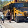 Des enfants montent dans un autobus scolaire.