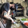 Un chef coupe des légumes dans un restaurant.