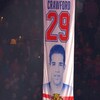 Une bannière en tissu avec le numéro 29, le mot Crawford et une photo du joueur est hissée au plafond de l'aréna.