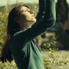 Gros plan sur l'actrice du film les bras en l'air.