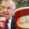 Ron Joyce a un café Tim Hortons à la main.