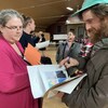 Une femme et un homme discutent en consultant des documents.