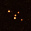 Cinq points orangés sur fond noir. L'image montre les étoiles en orbite très proche de Sgr A* (au centre), le trou noir supermassif au cœur de la Voie lactée.