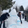 Des personnes font des sculptures de neige.