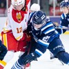 Deux joueurs de hockey bataillent pour la rondelle.