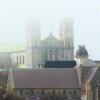 Les deux clochers d'une église disparaissent dans la brume.