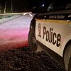 Une voiture de la Sûreté du Québec sur une route la nuit.
