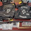Des armes, de la drogue et des vestes sur une table.