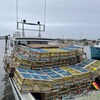 Un bateau rempli de casiers à homards dans le port de Baie Sainte-Anne.