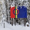 Un drapeau accroché à des arbres enneigés.